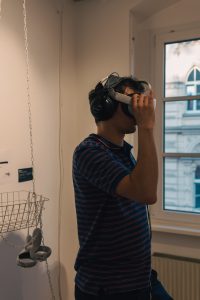 Bild von der "Between Times" Ausstellung 2022 - Ein Man mit aufgesetzter VR Brille